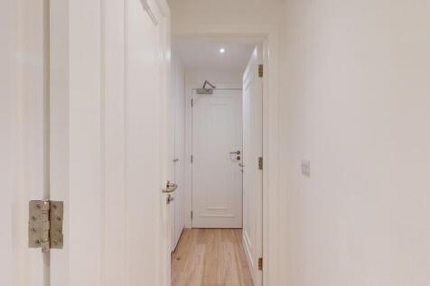 A clean and bright hallway with crisp white wal...