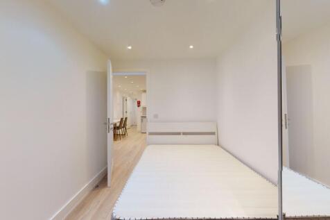 A bright and clean single bedroom featuring a n...