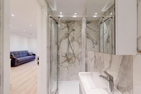 A modern bathroom featuring elegant marble-effe...