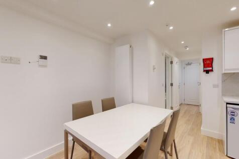 A modern kitchen dining area with a clean white...
