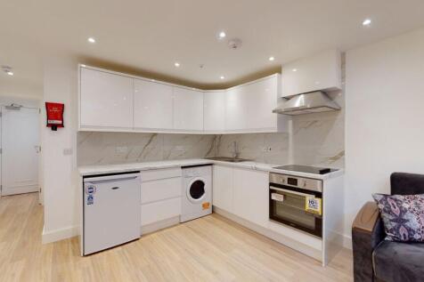 Modern kitchen with sleek white cabinets, integ...
