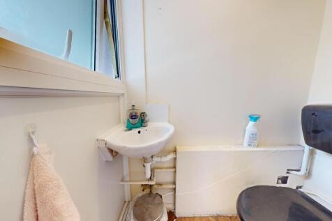 Compact and functional restroom featuring a sma...