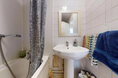 A compact bathroom featuring a white pedestal s...