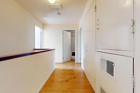 A bright and tidy hallway featuring polished wo...
