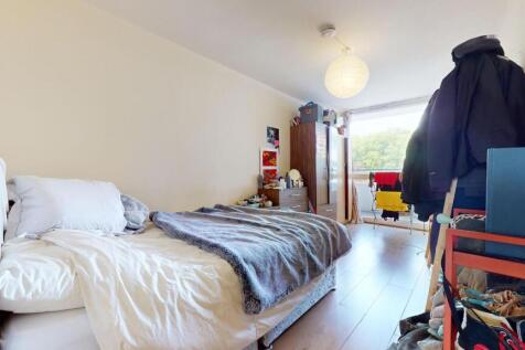A bright double bedroom featuring a large windo...