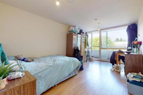 A bright and airy bedroom featuring a large win...