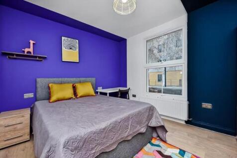 A bright and modern bedroom featuring a large b...