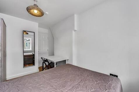 A bright, neatly arranged bedroom featuring a c...