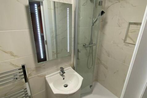 A modern, clean bathroom featuring a shower wit...
