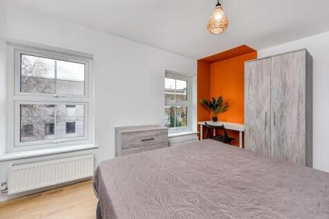 A bright and modern double bedroom featuring tw...
