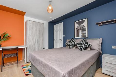 A modern bedroom featuring a comfortable double...