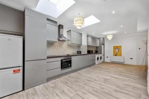 Modern and spacious kitchen featuring sleek gre...