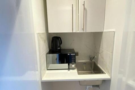 A modern kitchen featuring a compact workspace ...