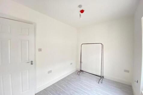 A bright and clean bedroom with white walls and...