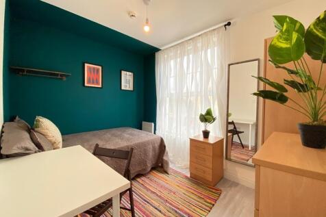 A bright and welcoming bedroom featuring a cozy...