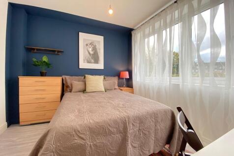 Bright and welcoming double bedroom featuring a...
