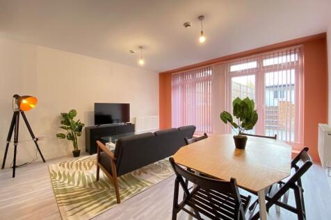 Bright and modern living room featuring a comfo...