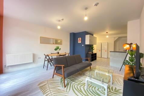A spacious, modern living room illuminated with...