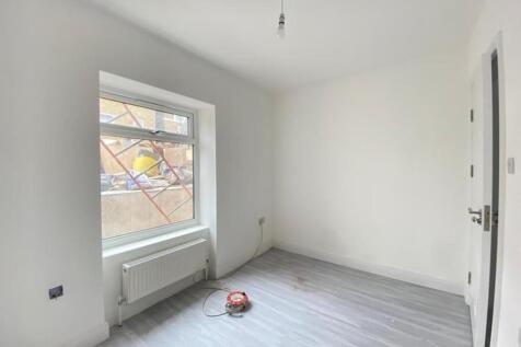 A bright, empty bedroom with freshly painted wh...