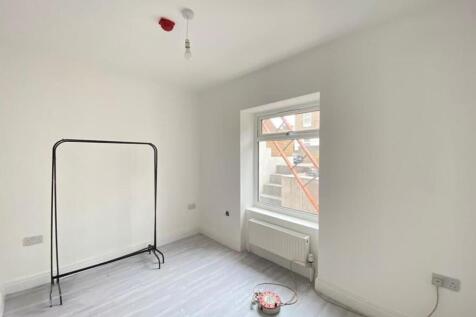 A bright, empty bedroom with white walls and a ...