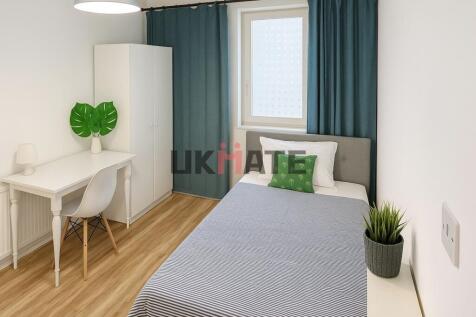 A bright and tidy bedroom featuring a comfortab...
