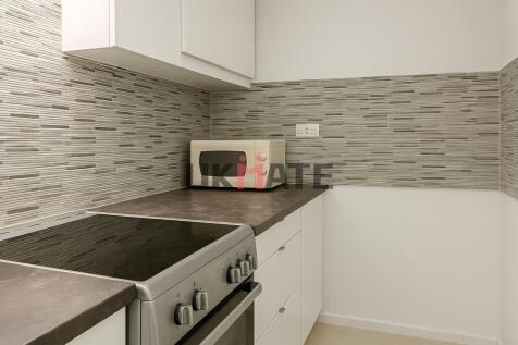 Modern kitchen area featuring a sleek counterto...