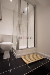 A modern bathroom featuring a clean shower cubi...