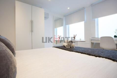A bright and modern bedroom featuring a comfort...