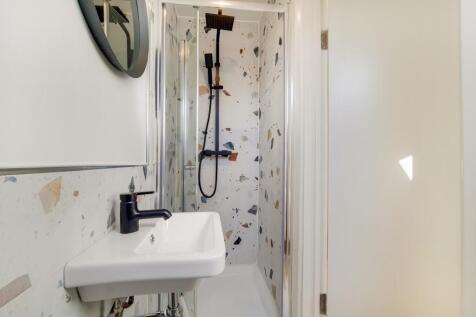 A clean and modern bathroom featuring a shower ...