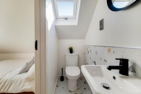 Bright and tidy bathroom featuring a toilet, sm...