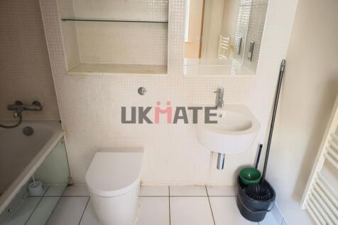 Functional bathroom featuring a toilet, a small...