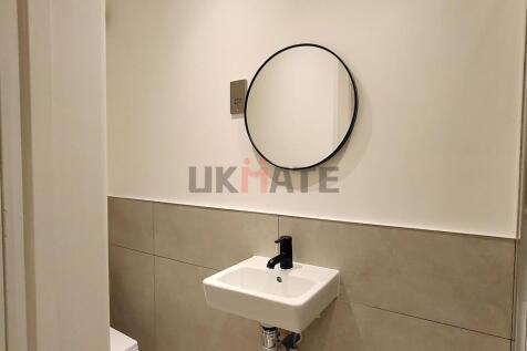 A modern compact bathroom featuring a small sin...