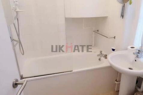 Bright and clean bathroom featuring a bathtub w...