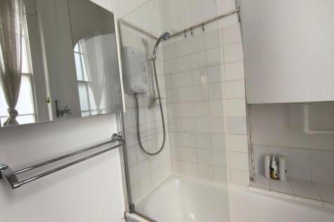 A clean and bright bathroom featuring a shower ...