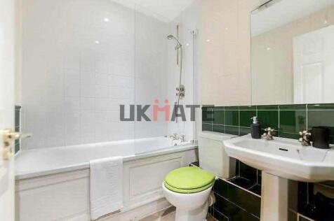 A clean and bright bathroom featuring a bathtub...