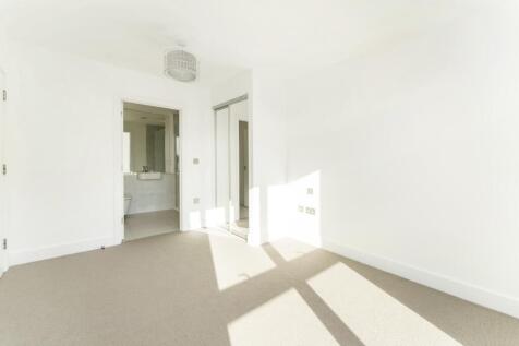 Bright and airy bedroom featuring clean, neutra...