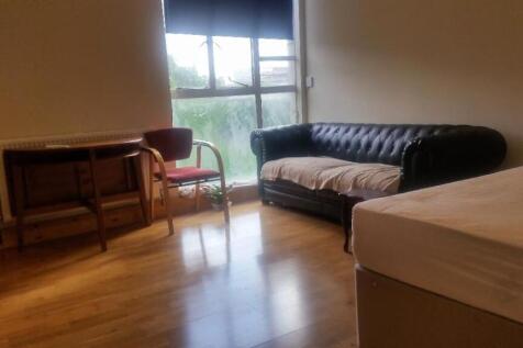 A cozy living room featuring a black leather so...