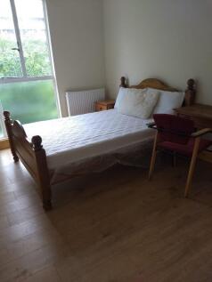 Bright double bedroom with wooden bed frame, be...