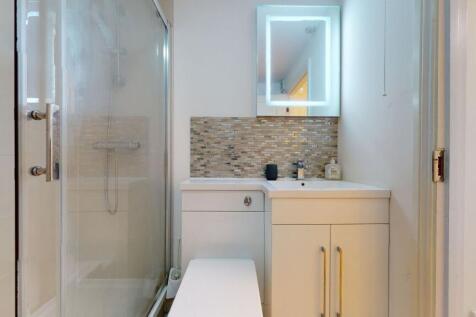 Modern bathroom featuring a glass-enclosed show...