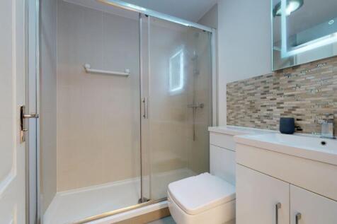 Modern bathroom featuring a spacious shower enc...
