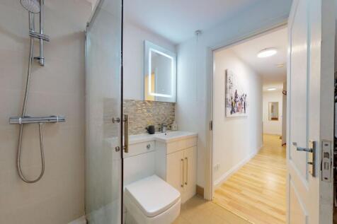 Modern bathroom featuring a sleek shower, a con...