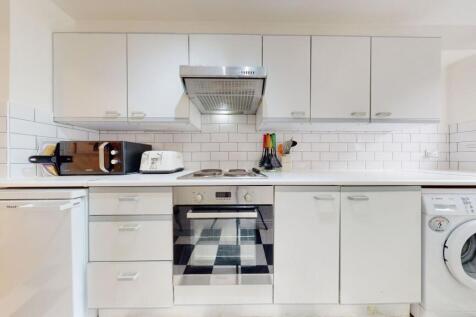Bright and modern kitchen featuring white cabin...