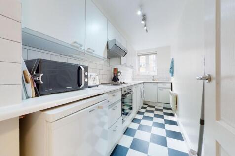 Bright and tidy kitchen with modern white cabin...