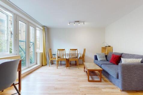 Bright and airy living room featuring large win...