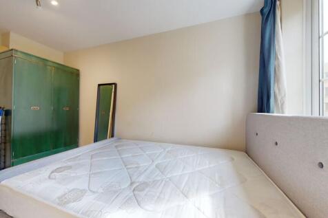 This well-lit bedroom features a comfortable be...