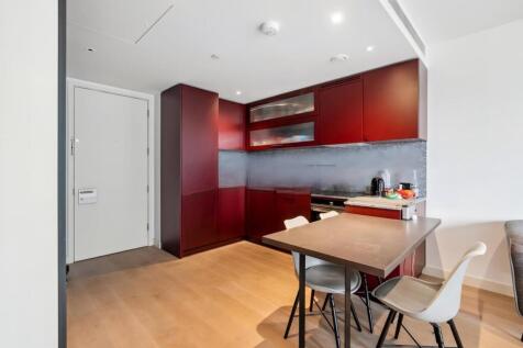 Modern kitchen with sleek red cabinetry, a comp...