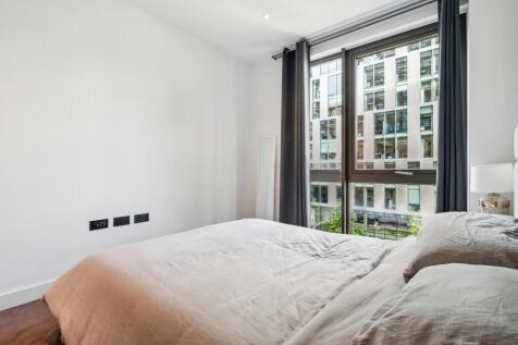 Bright and airy master bedroom with a large win...