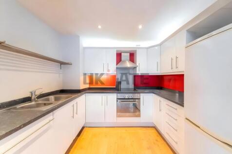 A modern, bright kitchen with white cabinets, a...