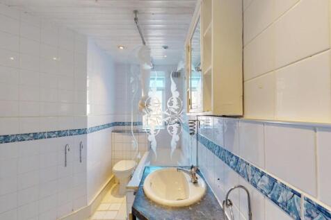 Bright and clean bathroom with a large bathtub,...
