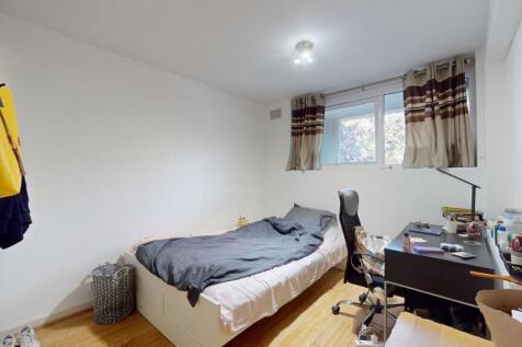 Simple, well-lit bedroom with a full-size bed, ...